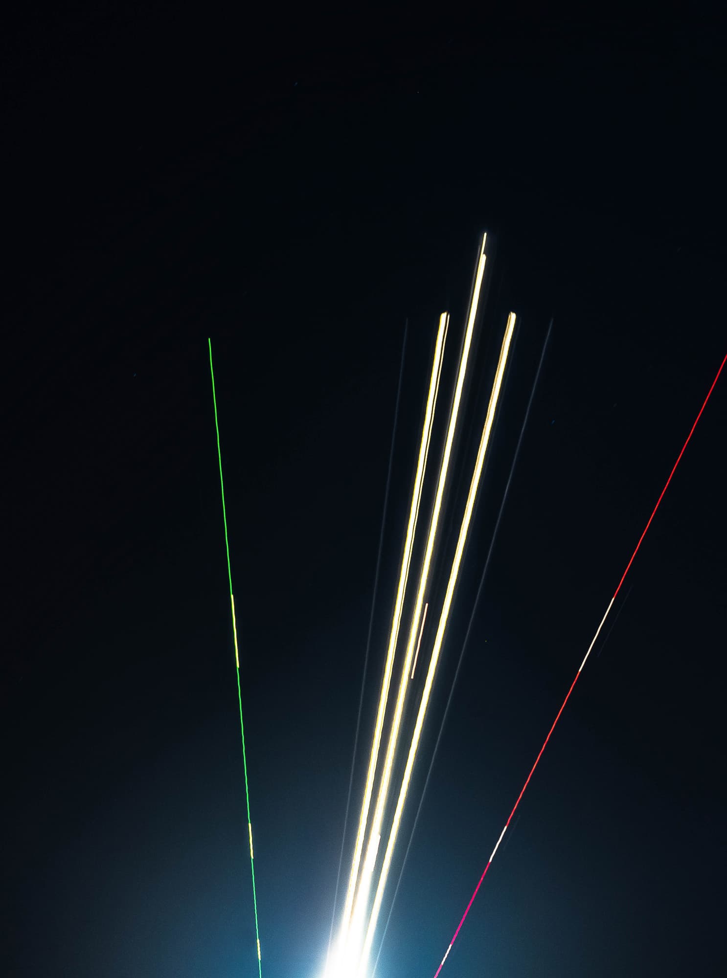 Light trails climbing into a black sky