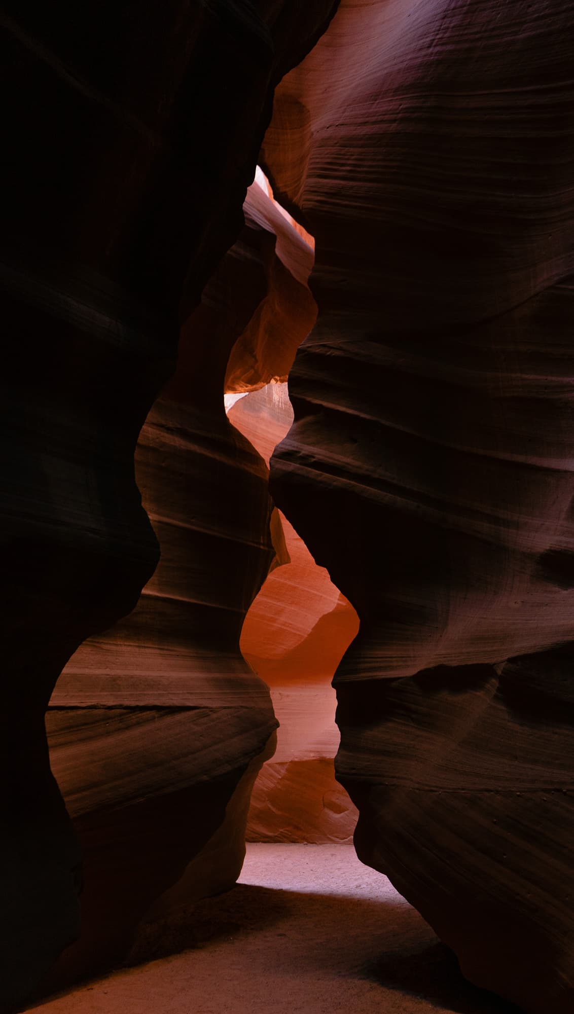 A slot canyon passage lit orange between dark walls