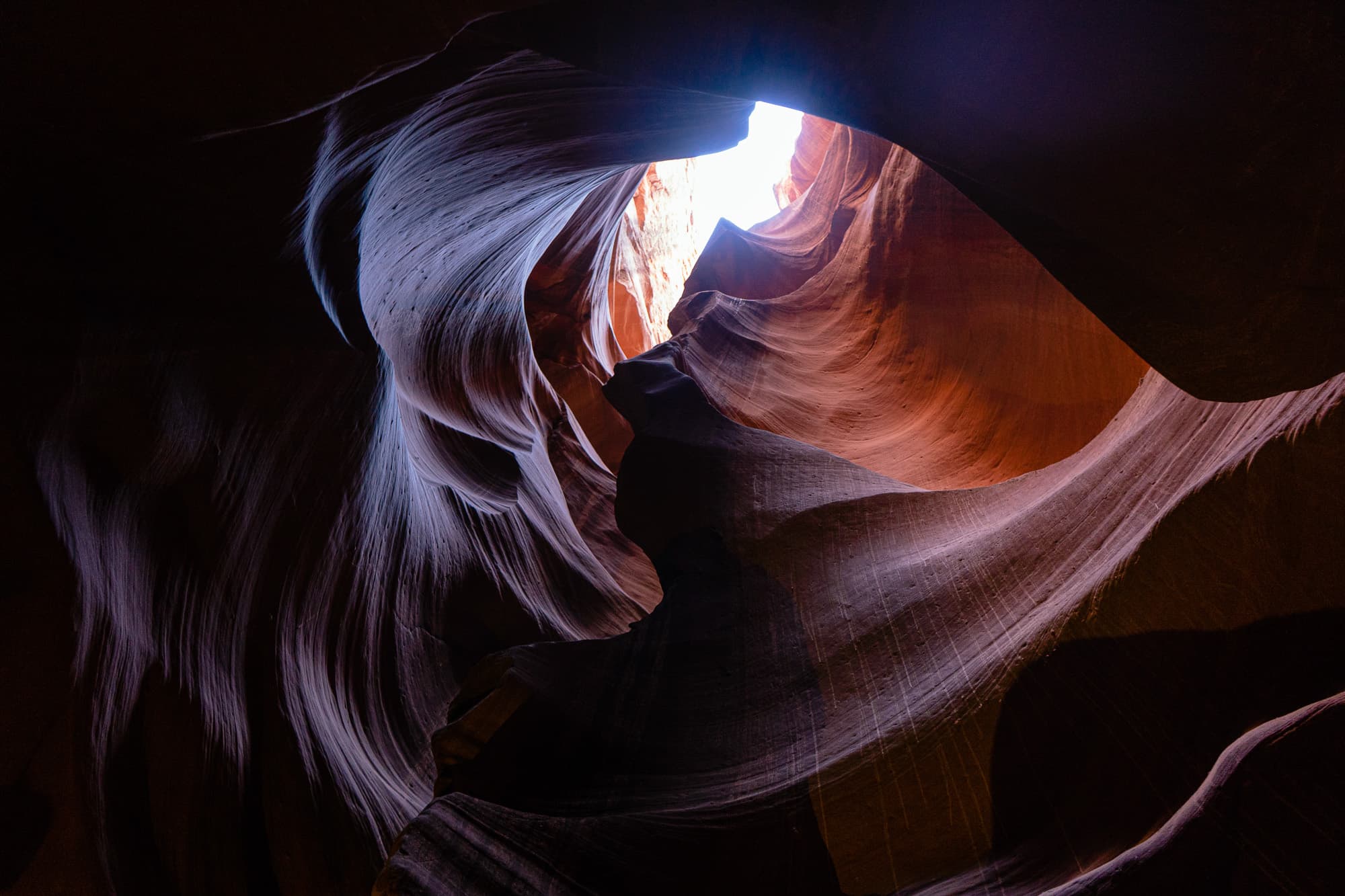 Sandstone canyon walls curving toward a small patch of sky