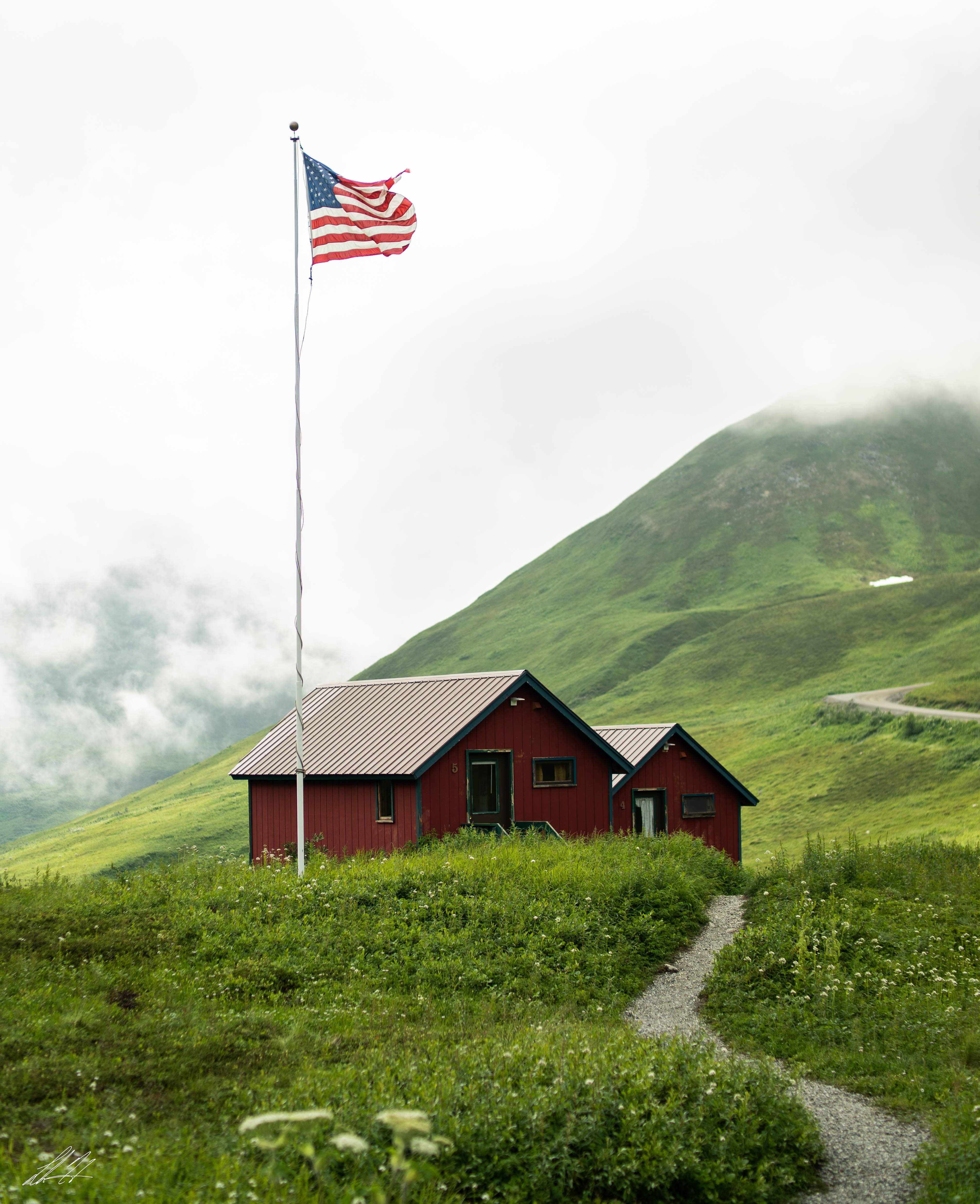 Red cabins and an American flag in misty green hills