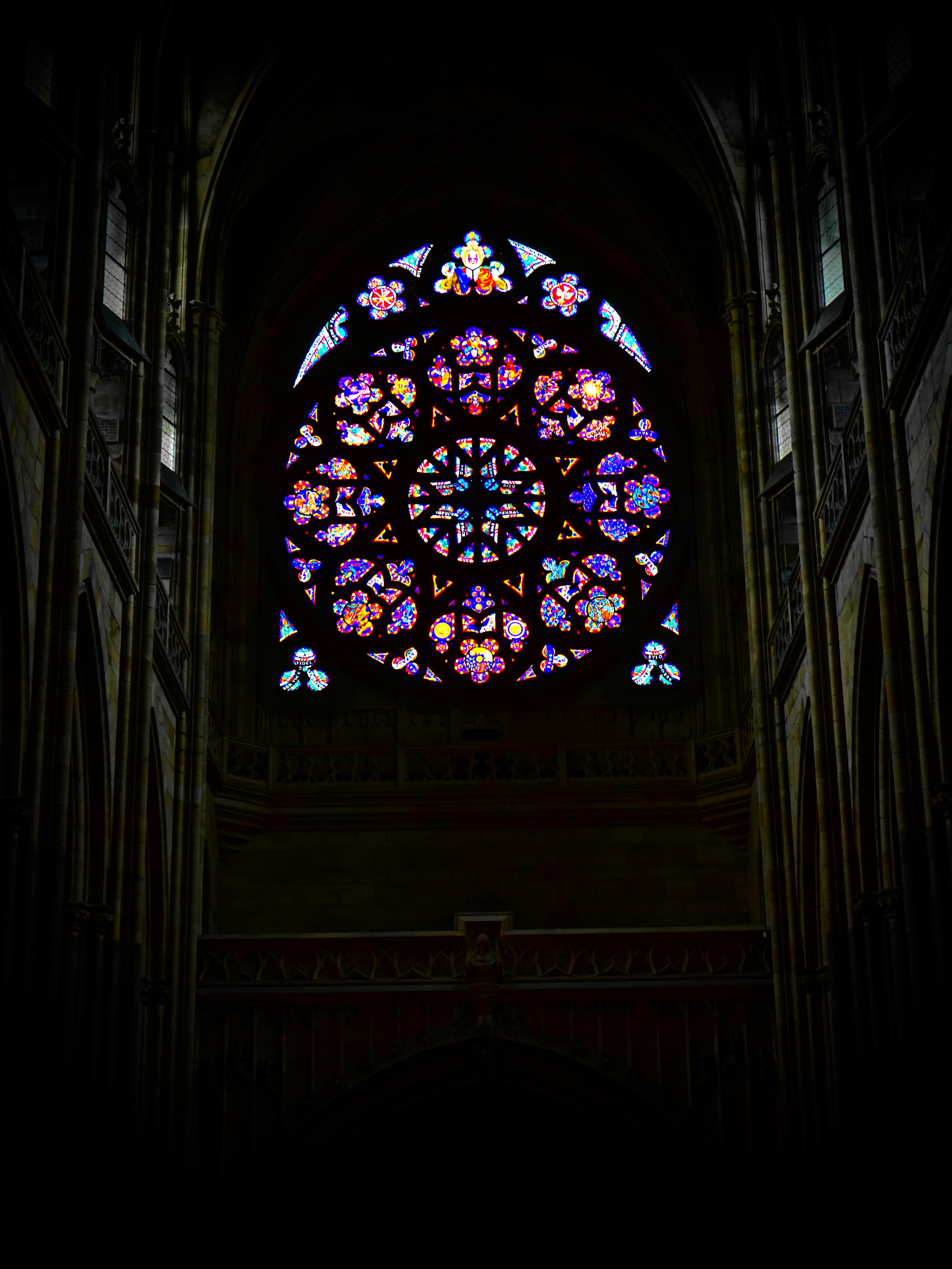 Dark cathedral interior framed toward a rose window