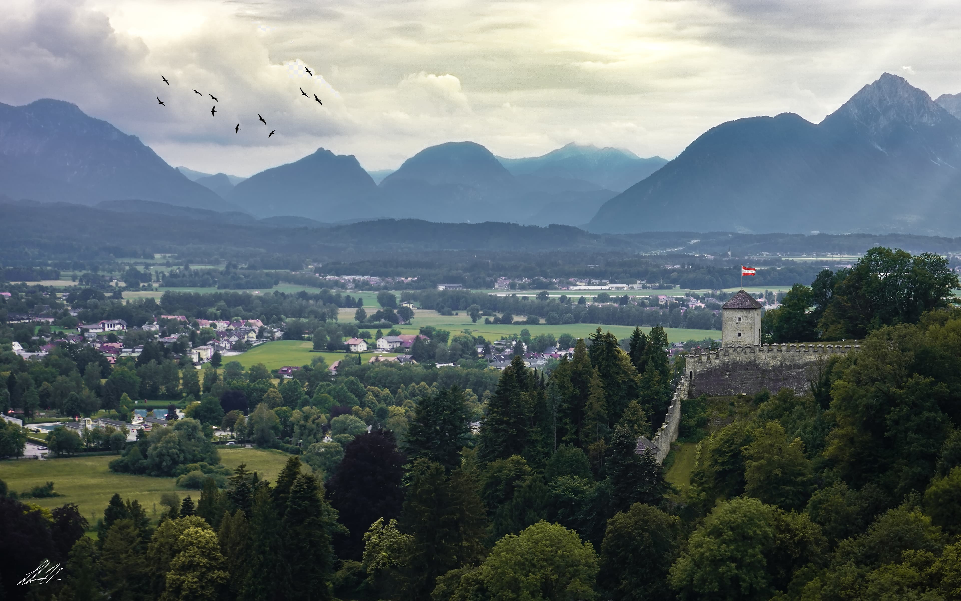 Salzburg valley fortress and mountains with birds in flight