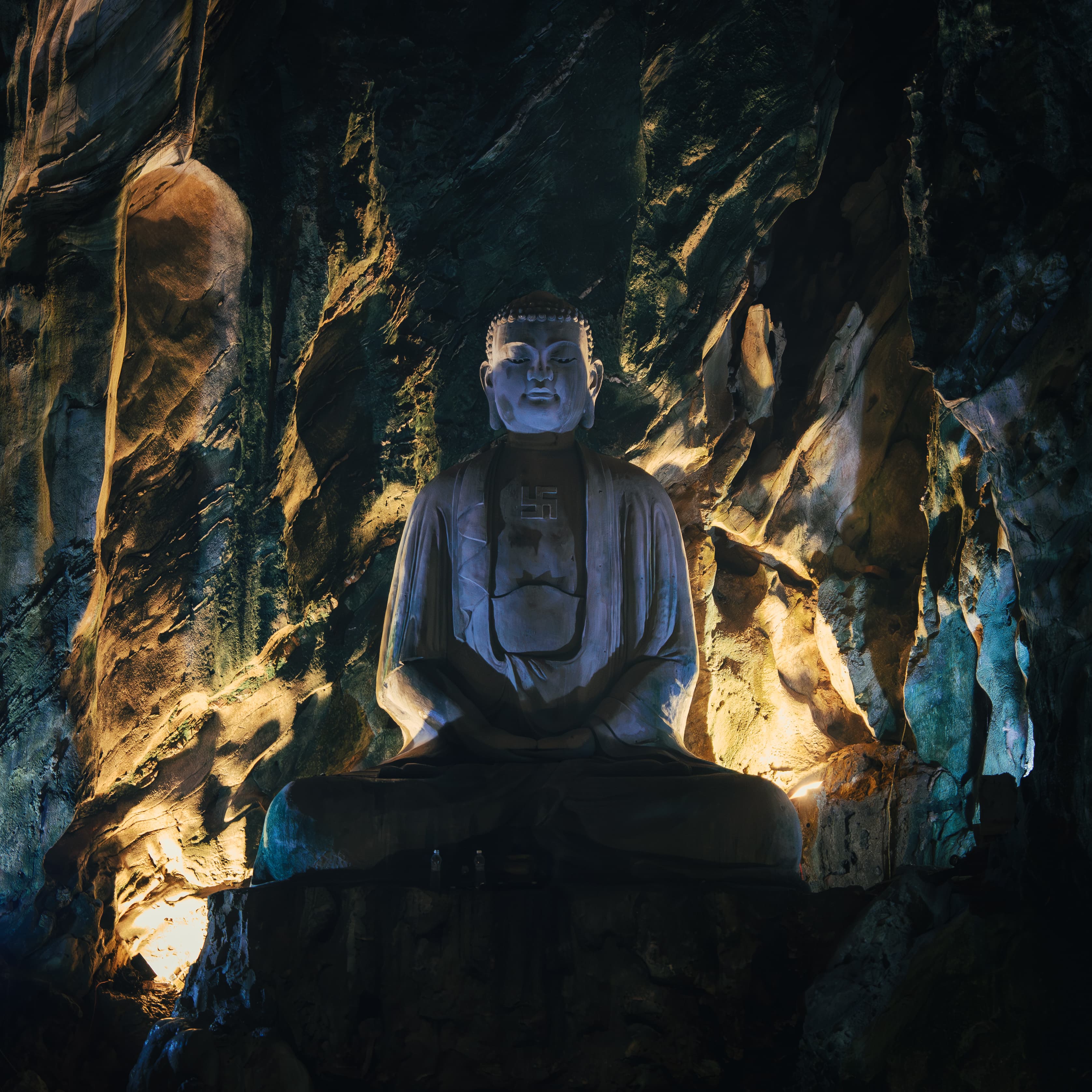 Atmospheric Buddha figure in a dark cave interior