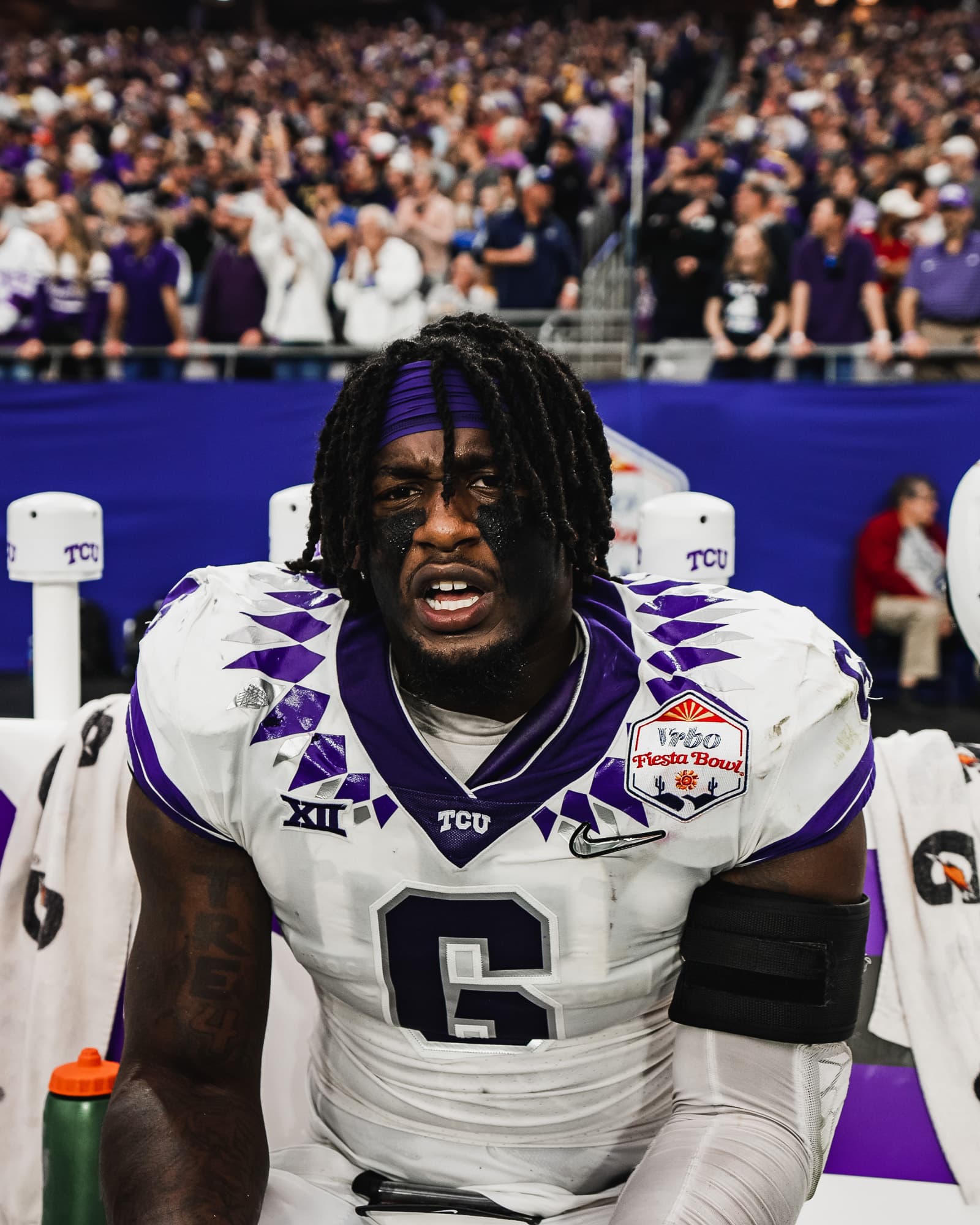 TCU player number 6 seated in an emotional sideline portrait