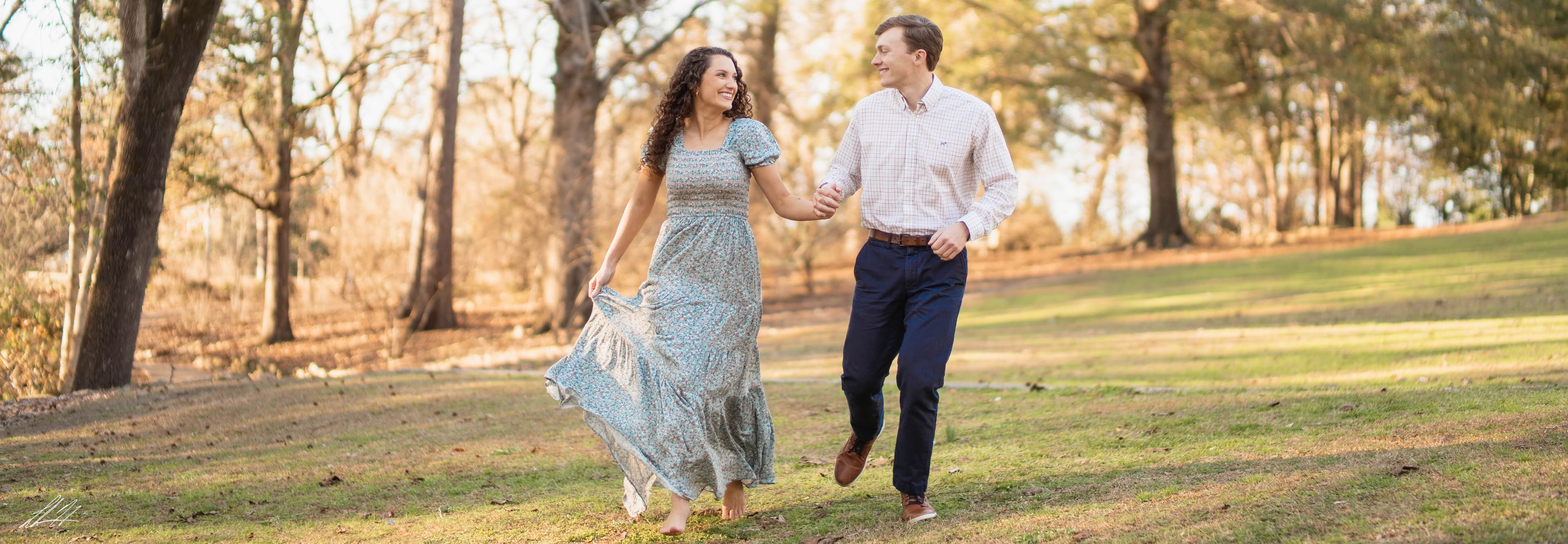 Couple walking hand in hand through an open field